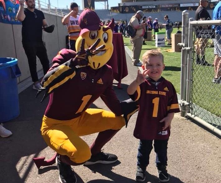 Sparky and a child at Frank Kush field